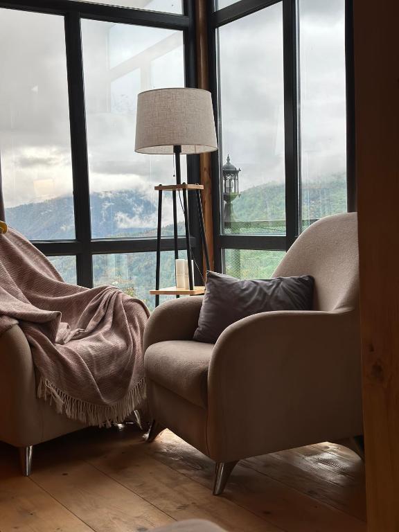 a living room with a couch and a large window at GR Qobu merisi in Inasharidzeebi