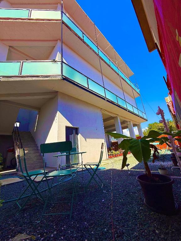 a building with chairs and a table in front of it at Zoon on in Costinesti