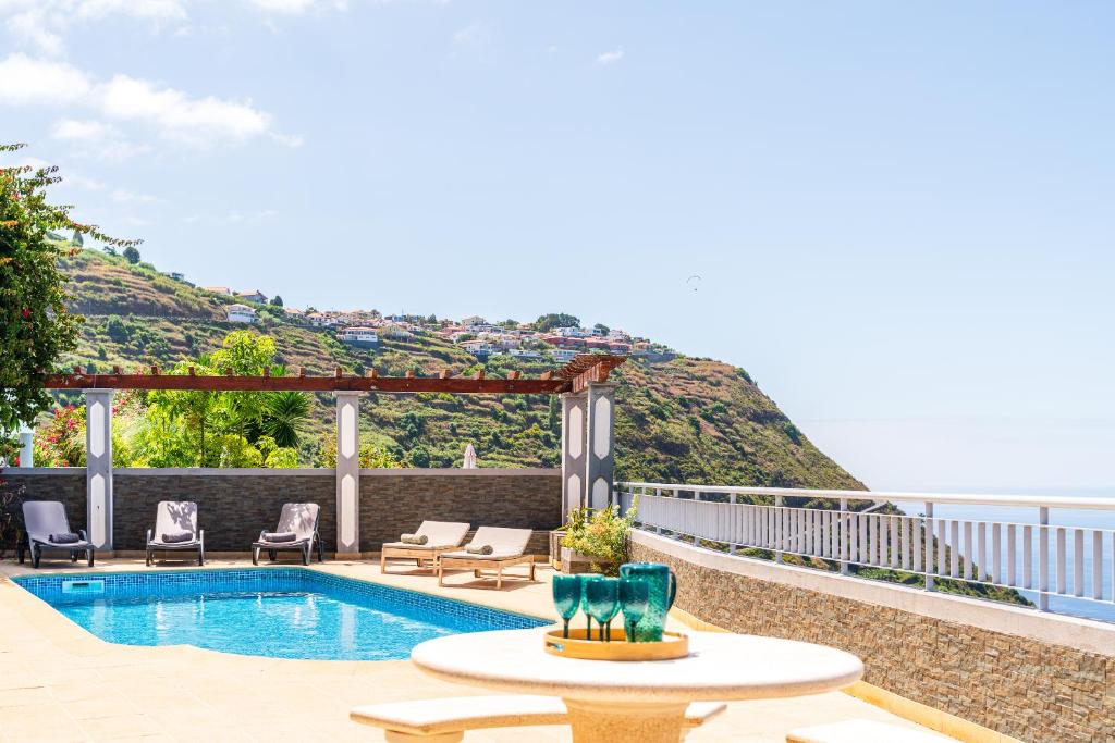 une piscine avec vue sur une montagne dans l'établissement Villa Abreu - A Wonderful Ocean View, à Calheta