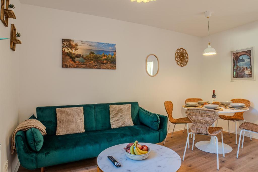a living room with a green couch and a table at Stylische Wohnung - Messe Essen nah - Wifi & Parken in Essen