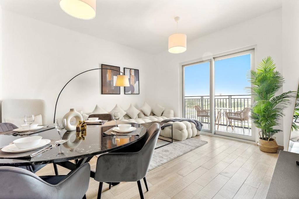 uma sala de estar com uma mesa e um sofá em FIRST CLASS 2BR Yas Island Living em Abu Dhabi