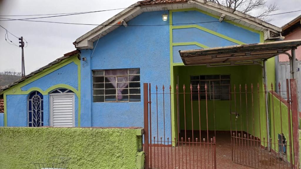 une maison bleue et verte avec un portail dans l'établissement Pousada Tia Marcia, à Cachoeira Paulista