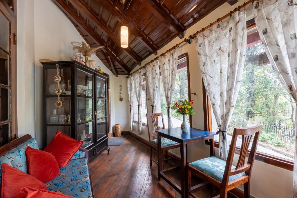 a living room with a table and chairs at Alaya Stays The Hive Cottage in Nainital
