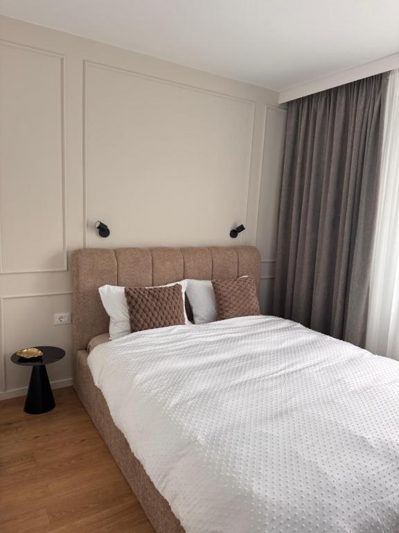 a bedroom with a large bed and a window at Olt view apartament in Călimăneşti