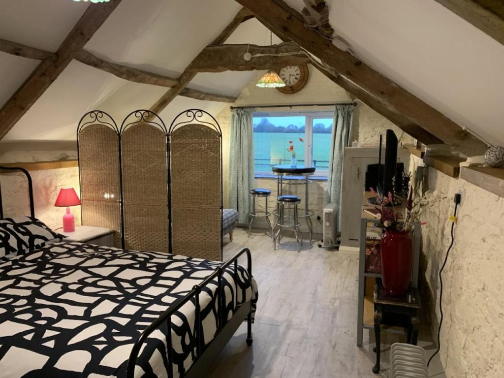 a bedroom with a bed and a view of the ocean at The Coach House at Stowford House in Babcary