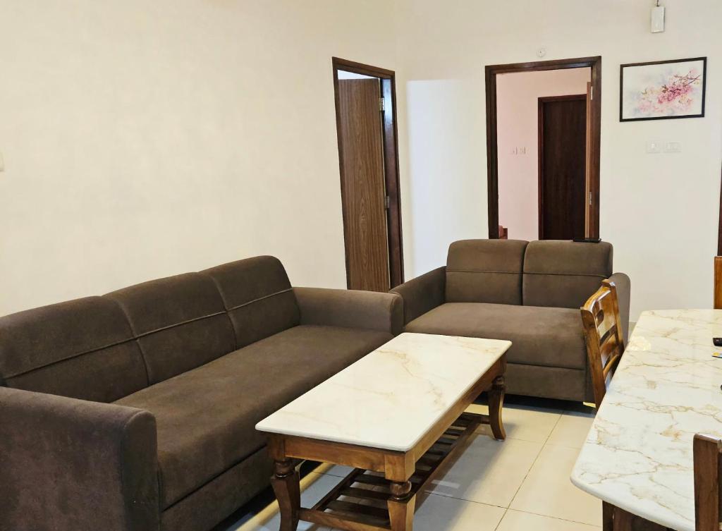a living room with a couch and a table at Cherry Blossom Hideaway Elegant 3BHK Cozy Ambience With Pool in Dabolim