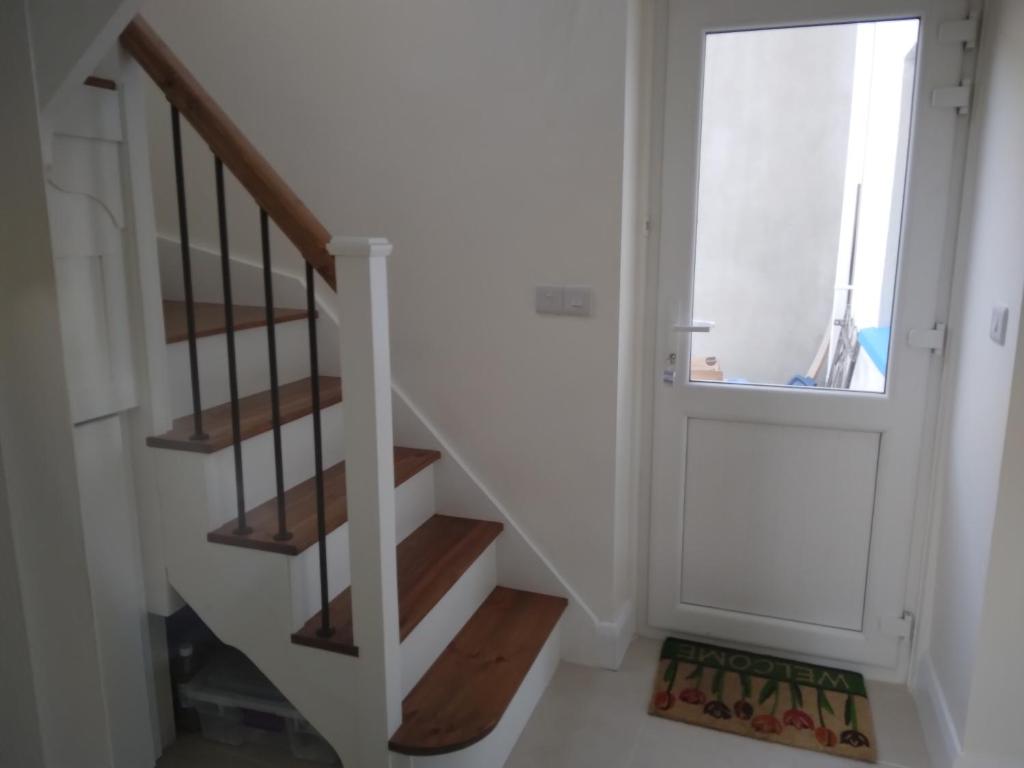 a staircase in a room with a door and a window at Seod Na Mara, Jewel of the Sea, Upstairs Flat, Dun Geagan,Ballinskelligs in Ballinskelligs
