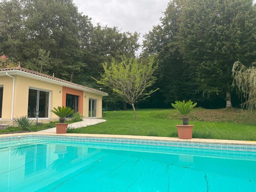 a swimming pool in front of a house at Maison au vert-Entre-Deux-Mers, Repos et confort au coeur de la nature in Cursan