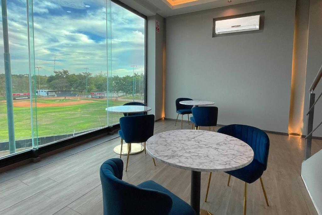 a room with two tables and chairs and a baseball field at Esplendor by Wyndham Los Mochis Country Place in Los Mochis