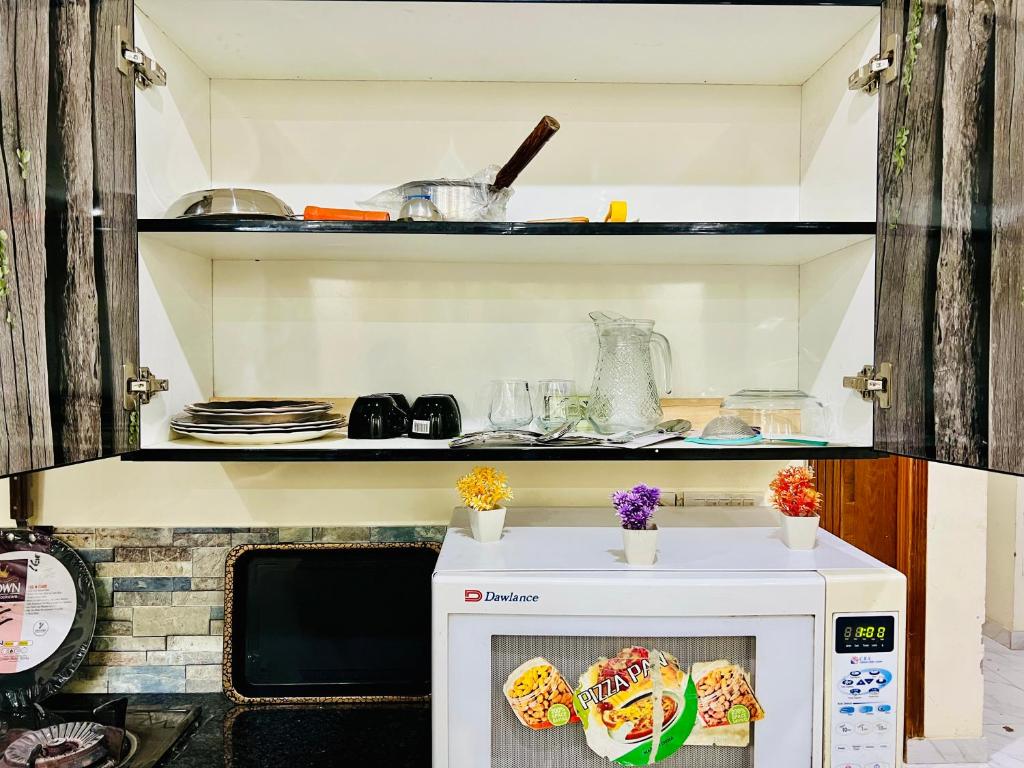 a kitchen with a microwave with some food on it at 1 bed furnished apartment flat Bahria town Rwp isb in Rawalpindi