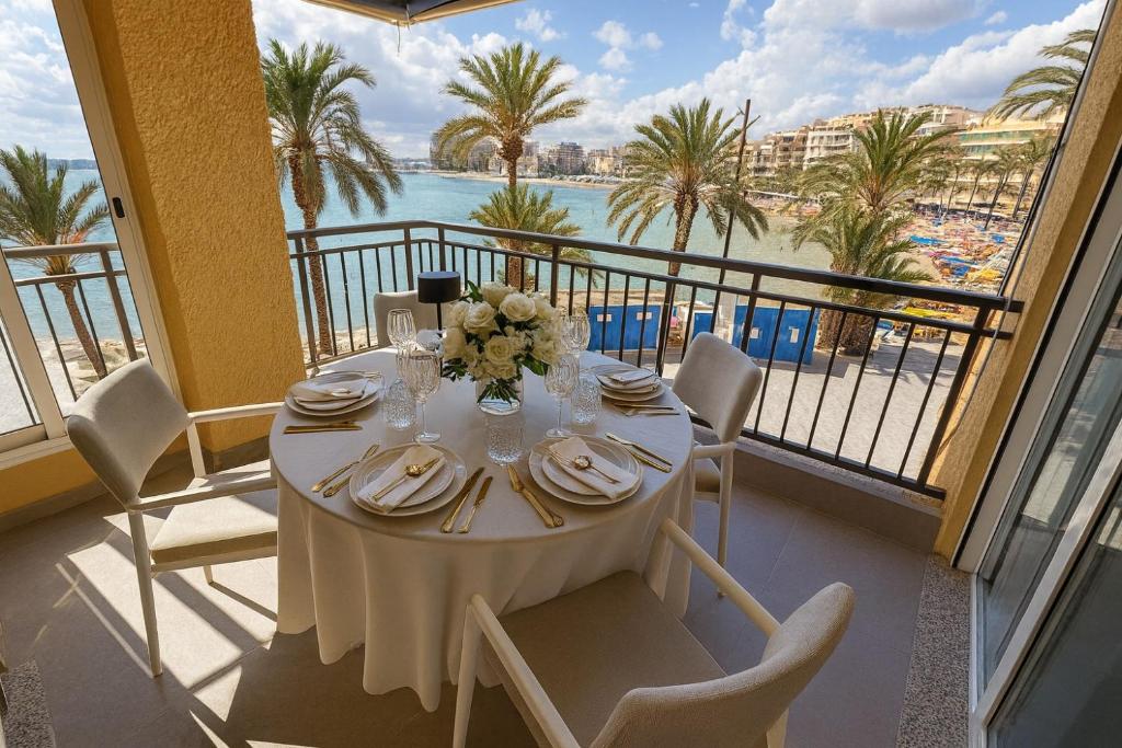 a white table with chairs and a view of the ocean at Sea View And Luxury On The Beach in Torrevieja