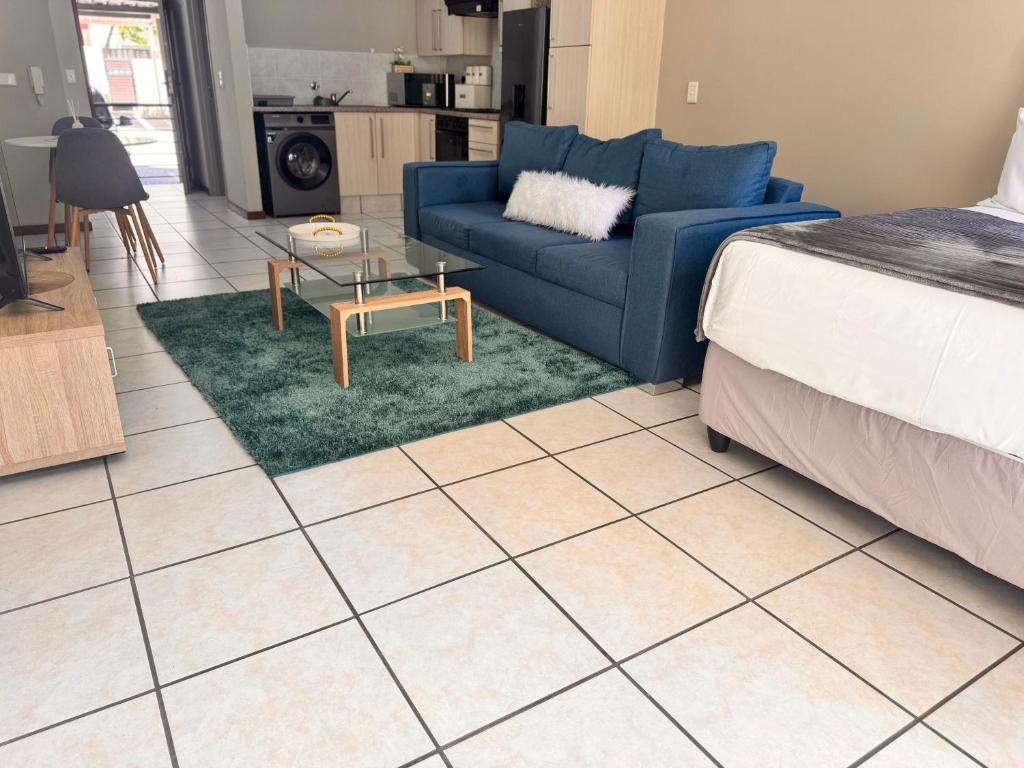 een woonkamer met een blauwe bank en een tafel bij Eden Place in Vosburg