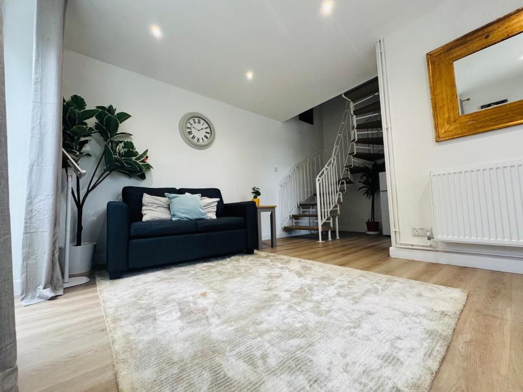 a living room with a blue couch and a rug at Modern 1 bedroom house in Lincolnshire