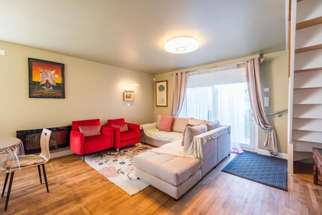 a living room with a white couch and red chairs at Maison familiale 8 personnes entre mer et campagne in Bégard