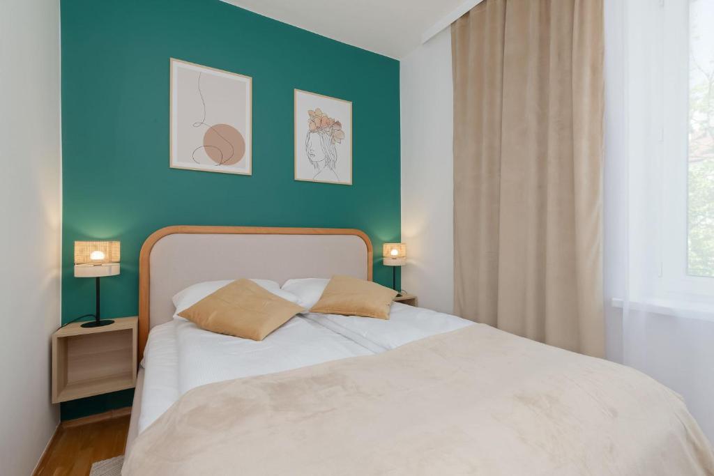 ein Schlafzimmer mit einem weißen Bett mit einer blauen Wand in der Unterkunft Atmospheric Apartment in a Green Area Pet-friendly by Noclegi Renters in Wzgórze Nowotki