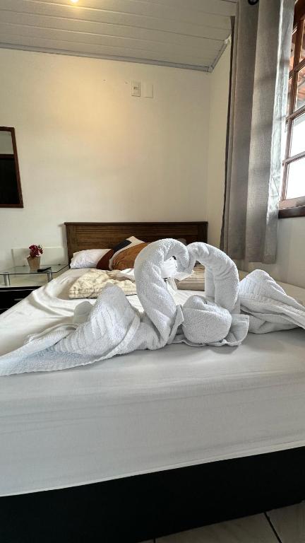 a bed with two towels on top of it at Pousada estação do mar in Florianópolis