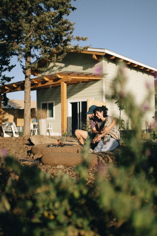 a man and woman sitting in front of a house at Matar baYaar מטר ביער in El-Rom