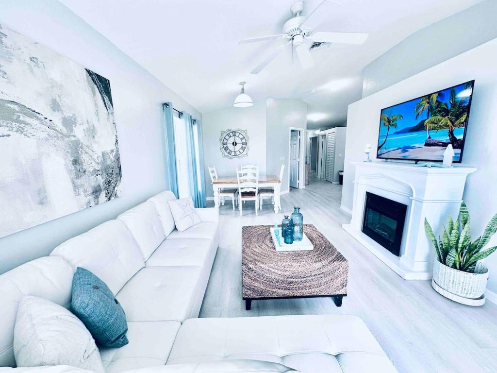 a living room with a white couch and a fireplace at Cape Coral Seascape in Cape Coral