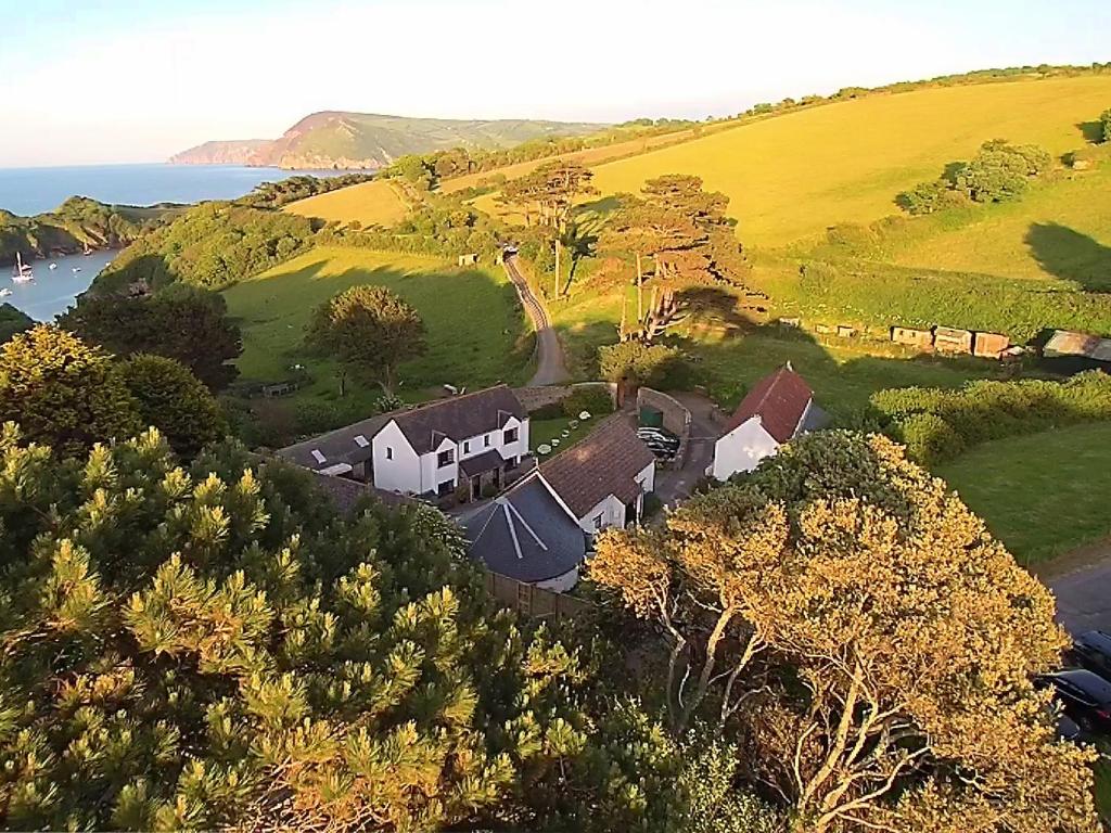 - une vue aérienne sur une maison située sur une colline à côté de l'océan dans l'établissement Partridge Cottage, à Ilfracombe