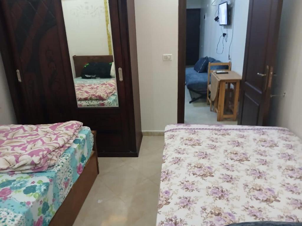 a bedroom with two beds and a mirror at Golf Porto Marina El Alamein studio Aqua 52111 in El Alamein