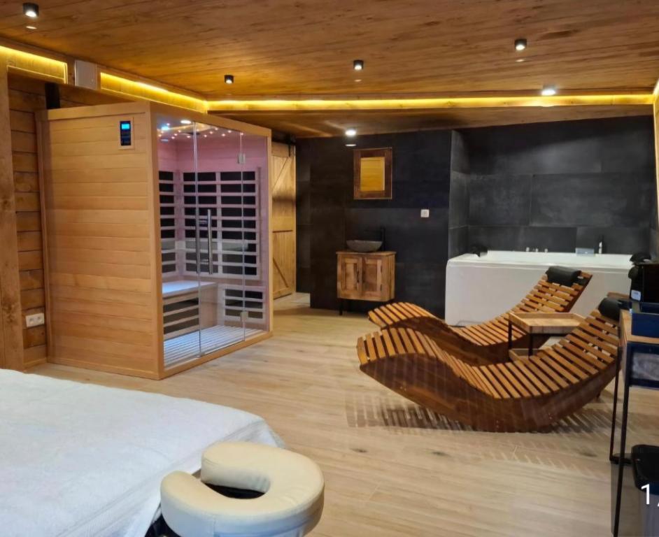 a bedroom with a bed and a table and chairs at Chambre spa eden in Sainte-Ode