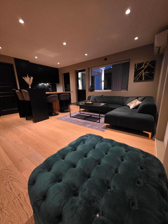 a living room with a large blue ottoman at Aurora View Apartment - Free Parking & Walkable City Location in Tromsø