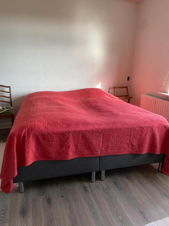 a bedroom with a red blanket on a bed at Vestergård B&B in Varde