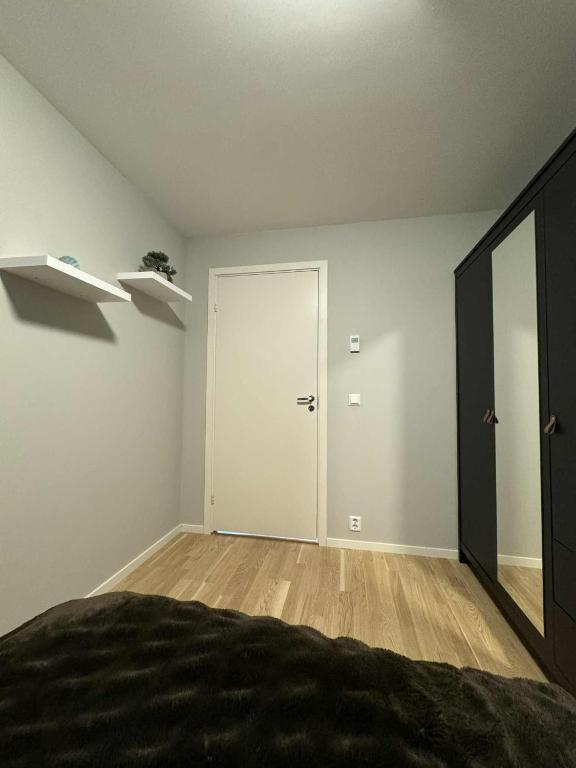 1 dormitorio con puerta blanca y espejo en Modern townhouse in Lofoten, en Leknes