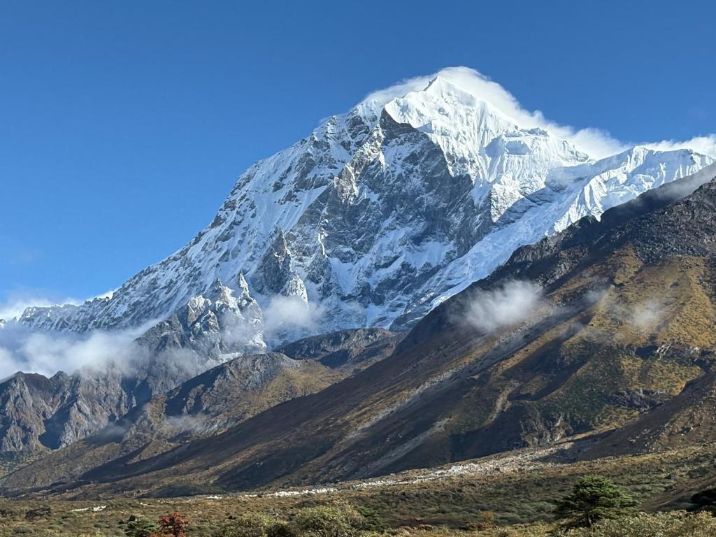 a snow covered mountain with clouds in front of it at Walk in Himalayas in Pelling