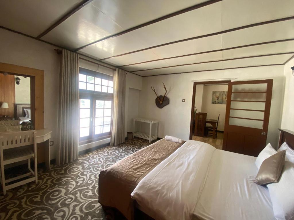 ein Hotelzimmer mit einem Bett und einem Badezimmer in der Unterkunft Peak View Cottage in Nuwara Eliya