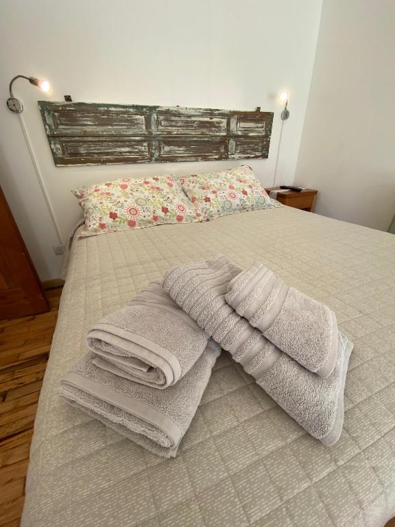 a pile of towels sitting on top of a bed at Inti Laufquen in San Carlos de Bariloche