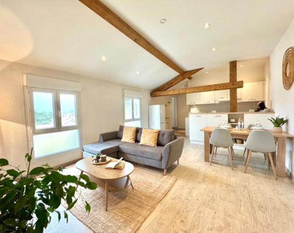 a living room with a couch and a table at Le Cocon Céleste - Appartement d'Exception - Vue sur les Alpes - Centre-Ville - Gare à 1 min in Valence