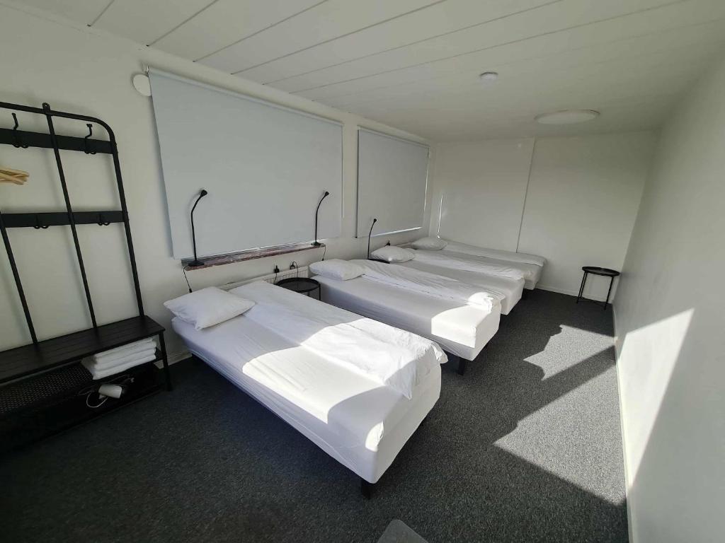 a room with four beds and a window at Office Motel in Gothenburg
