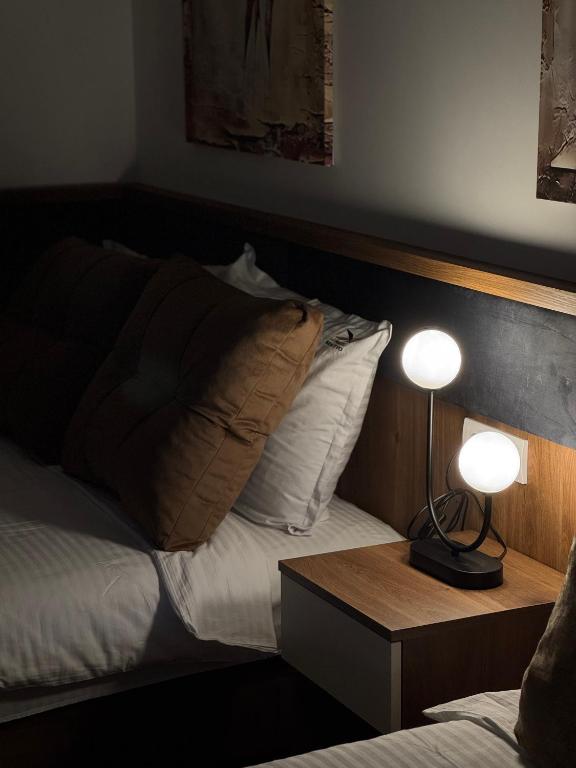 a bedroom with a bed with two lamps on it at Motel Krnjevo OAZA in Krnjevo