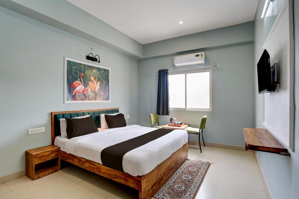 Un dormitorio con una cama, una mesa y un televisor. en Collection O Udaipur City Railway Station Formerly Shree Ganesh Guest House, en Udaipur