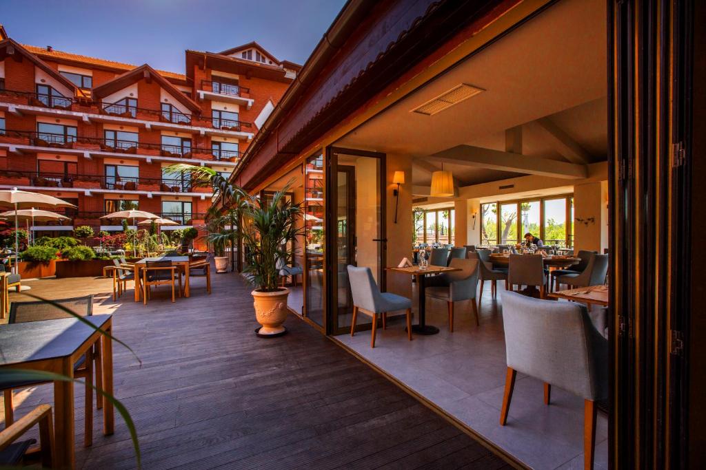 a restaurant with tables and chairs on a deck at Caro Hotel in Bucharest