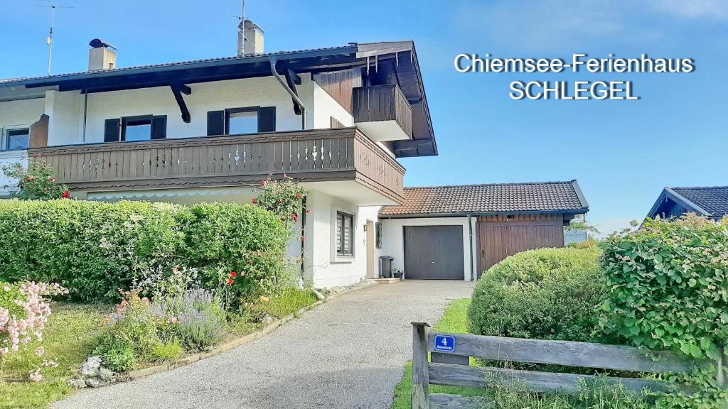 a white house with a fence in front of it at Chiemsee-Ferienhaus Schlegel in Breitbrunn am Chiemsee