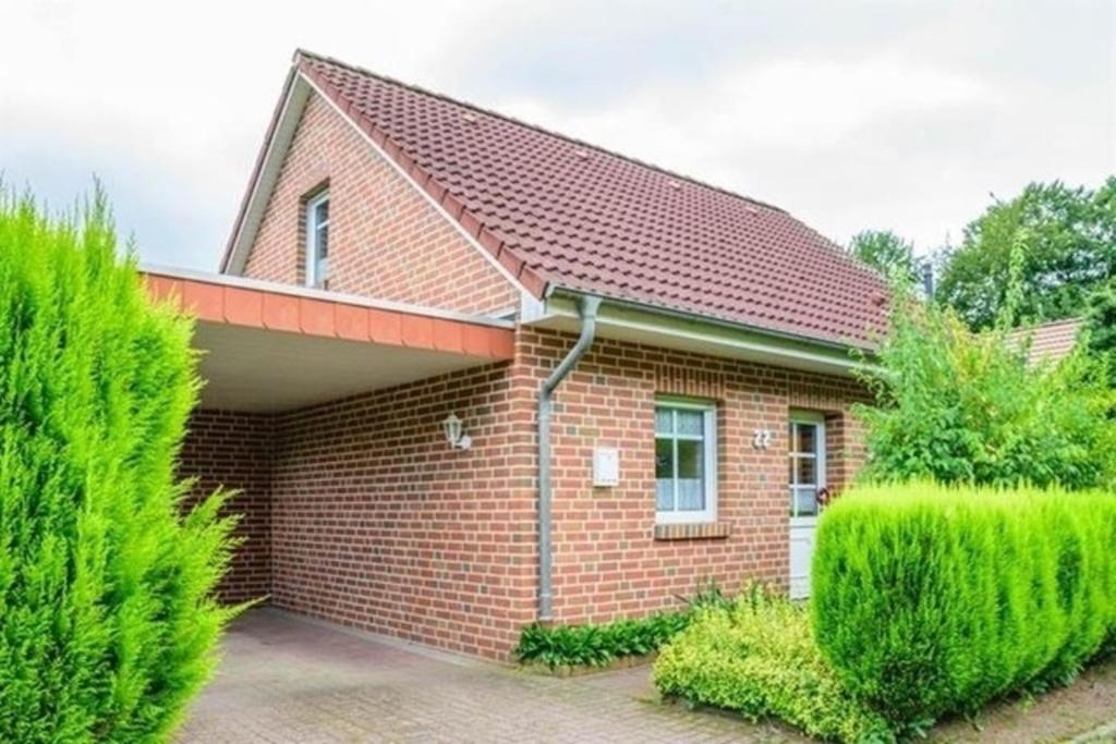 a red brick house with bushes in front of it at Margret HA22 in Sögel