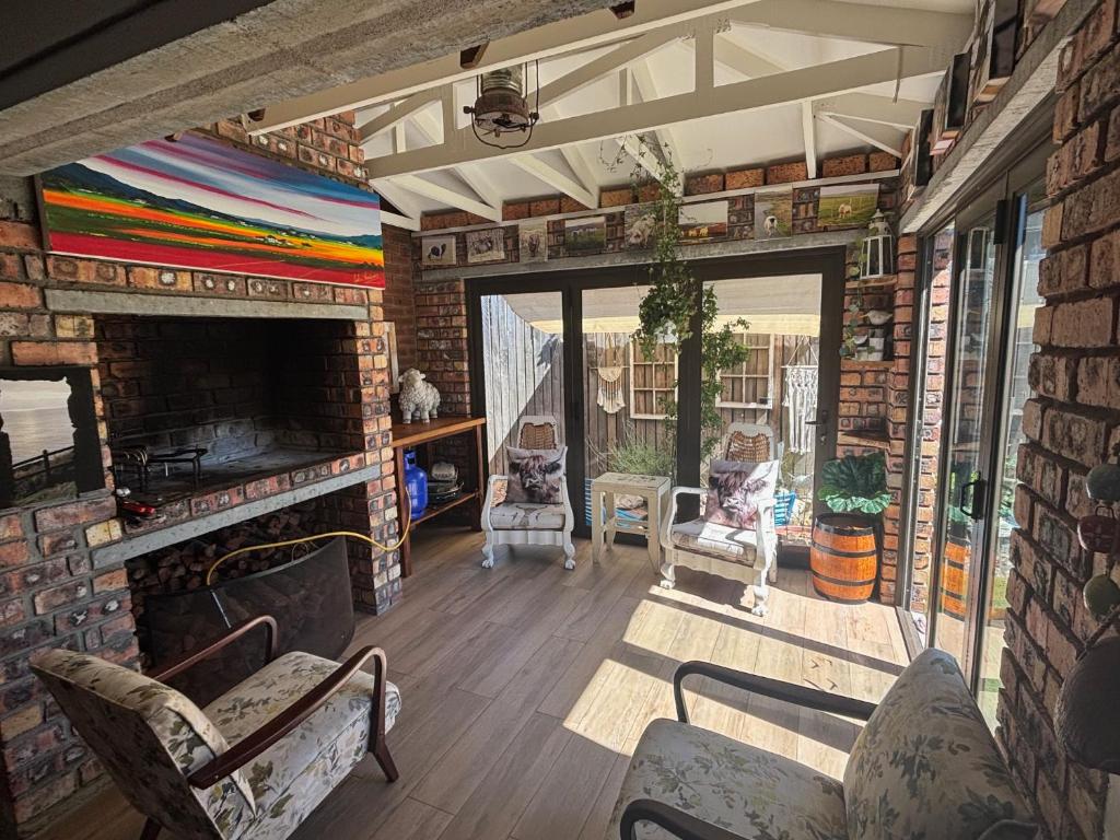a living room with a fireplace and a brick wall at Vintage Tide in Cape Town