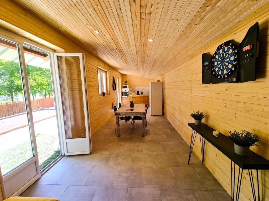 a dining room with a table and a dartboard on the wall at Le chalet au bord de seine in Les Mousseaux