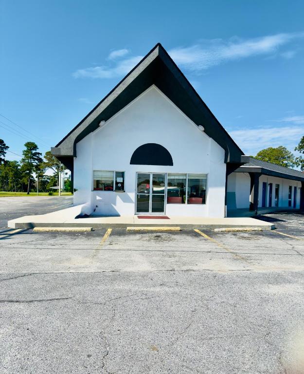 ウィリアムストンにあるRoss Motelの黒屋根白い建物