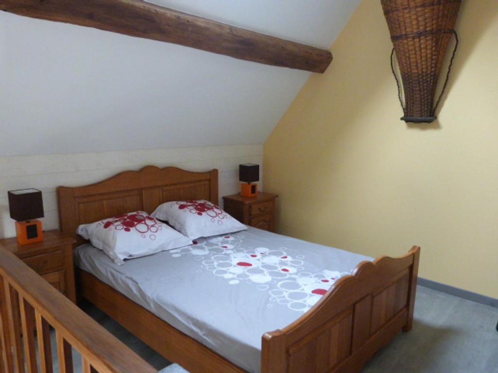 ein Schlafzimmer mit einem Bett mit roten Blumen darauf in der Unterkunft Le Bocard in Thonnance-lès-Joinville