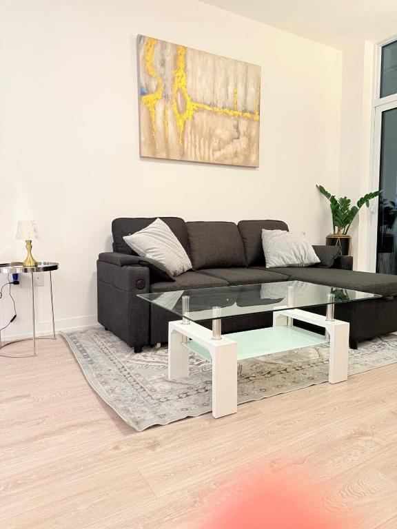 - un salon avec un canapé noir et une table en verre dans l'établissement Executive Condo in Prime Erin Mills Location l Walk to Mall and Hospital, à Mississauga