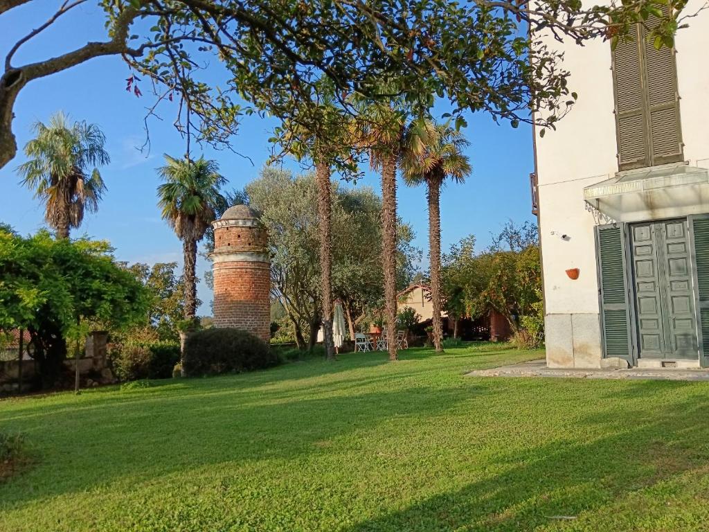 a brick lighthouse in a yard with palm trees at BotanicaSuiteTorino in Baldissero Torinese