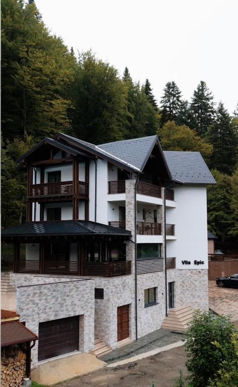 a large white house with a black roof at Vila Epic&Slanic Moldova in Slănic-Moldova