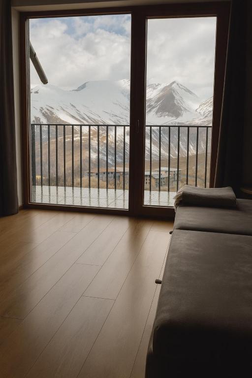 Habitación con ventana grande con vistas a la montaña. en Alpine Vista Gudauri, en Gudauri