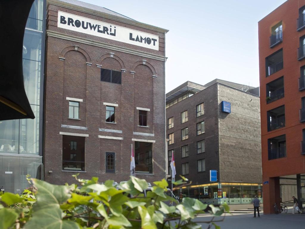 a brick building with a sign on top of it at Novotel Mechelen Centrum in Mechelen