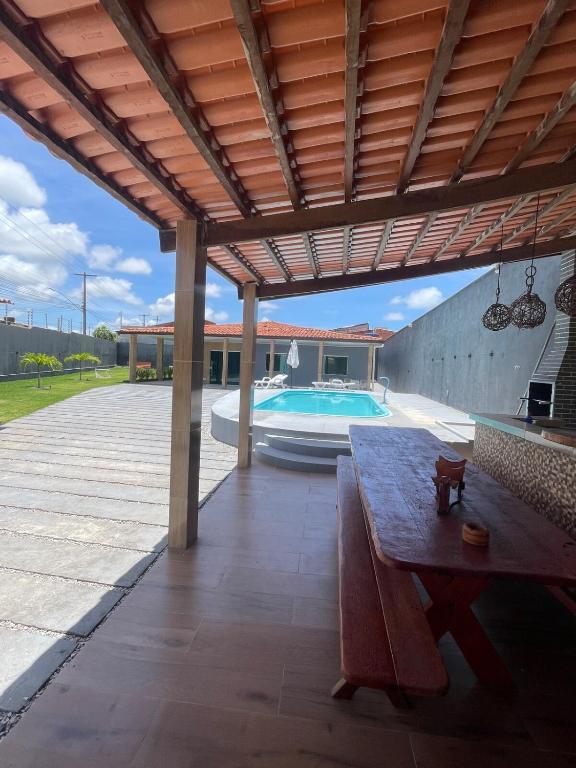 patio z ławką i basenem w obiekcie Casa de praia na Barra de São Miguel w mieście Barra de São Miguel