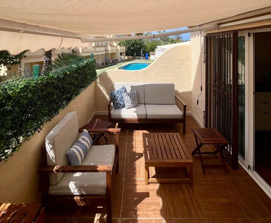 eine Außenterrasse mit Sofas, Tischen und einem Pool in der Unterkunft Denia, playa y ciudad in Denia