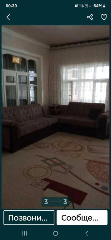 sala de estar con sofá y alfombra en Lucky Hostel oilaviy korxona, en Yakkasaray